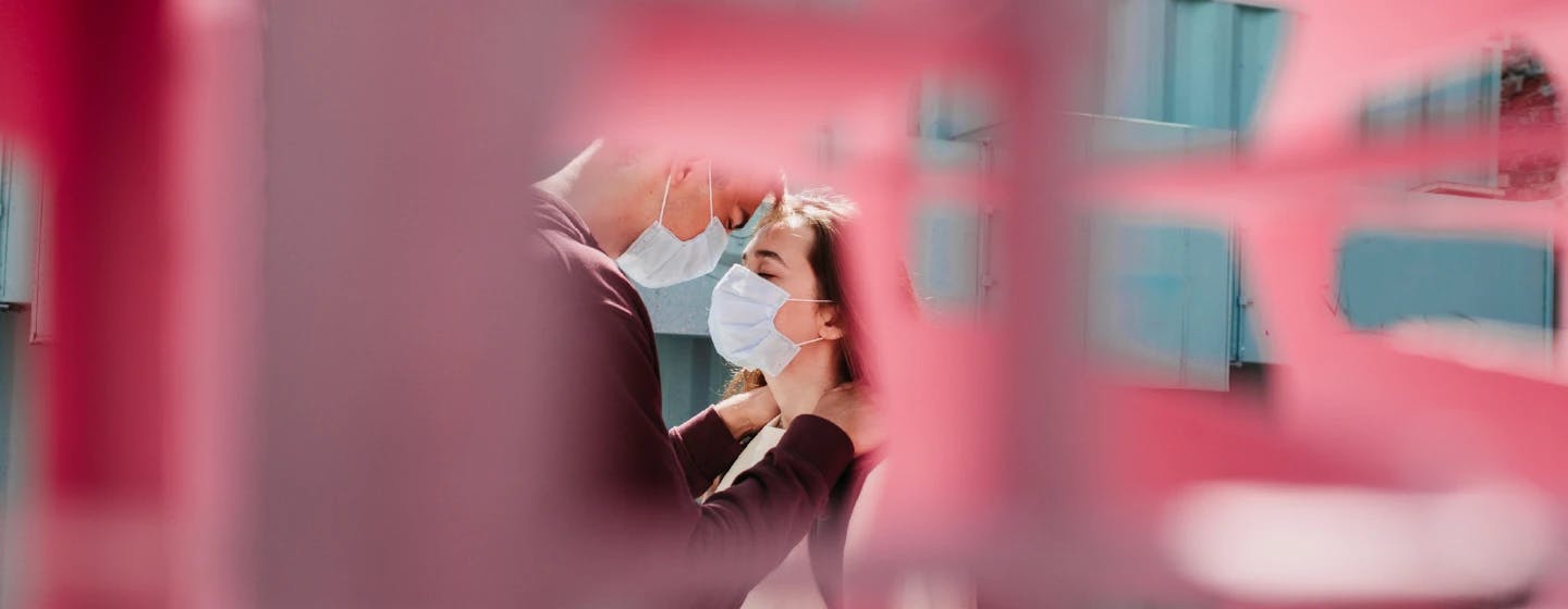 two people embracing in hygiene masks, representing the need for human connection during covid pandemic
