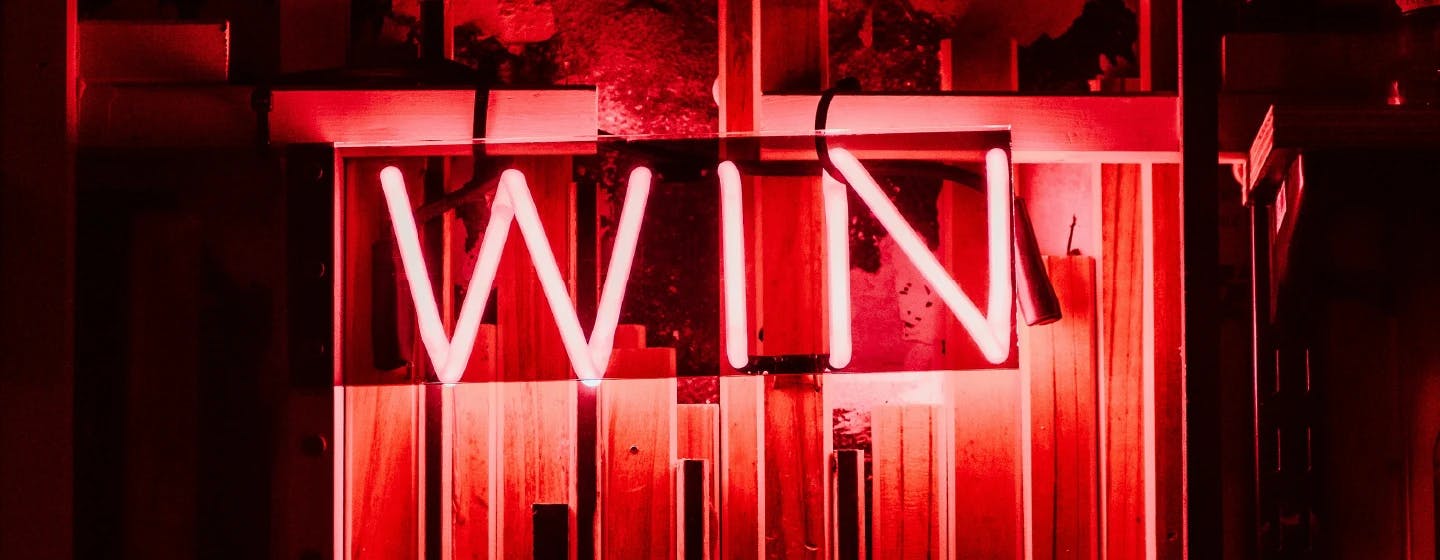 a neon sign that says "win" representing firefish's gold trophy and overall grand ogilvy win at the advertising research foundation awards 2022